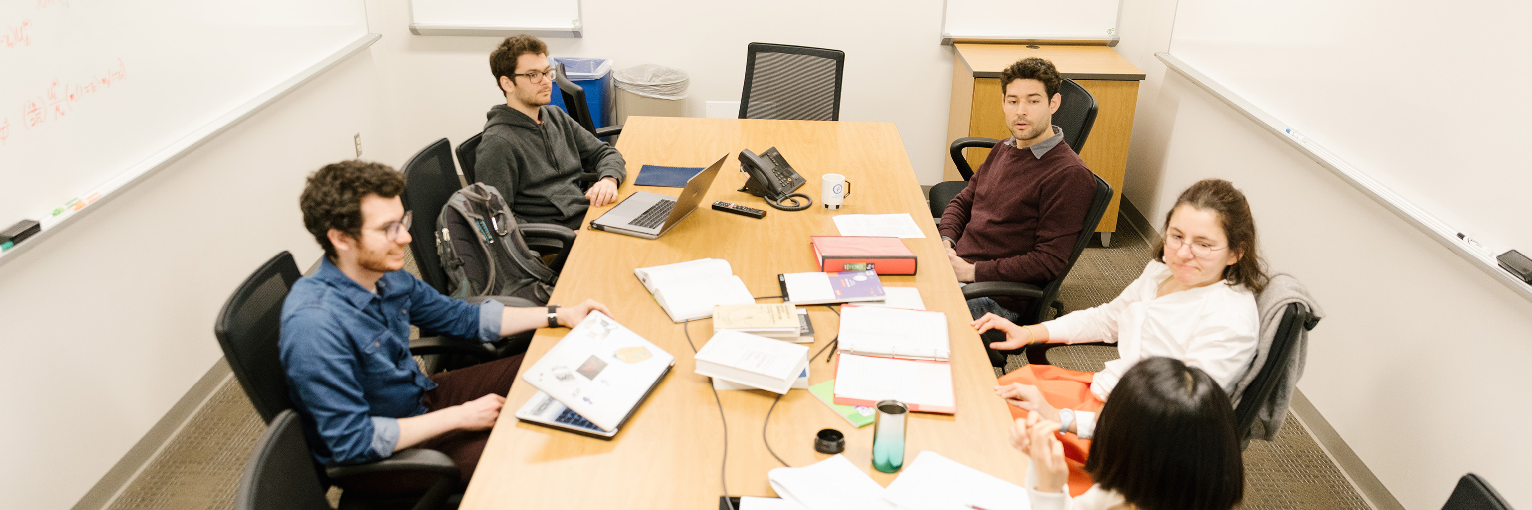 Graduate students convened around a conference table