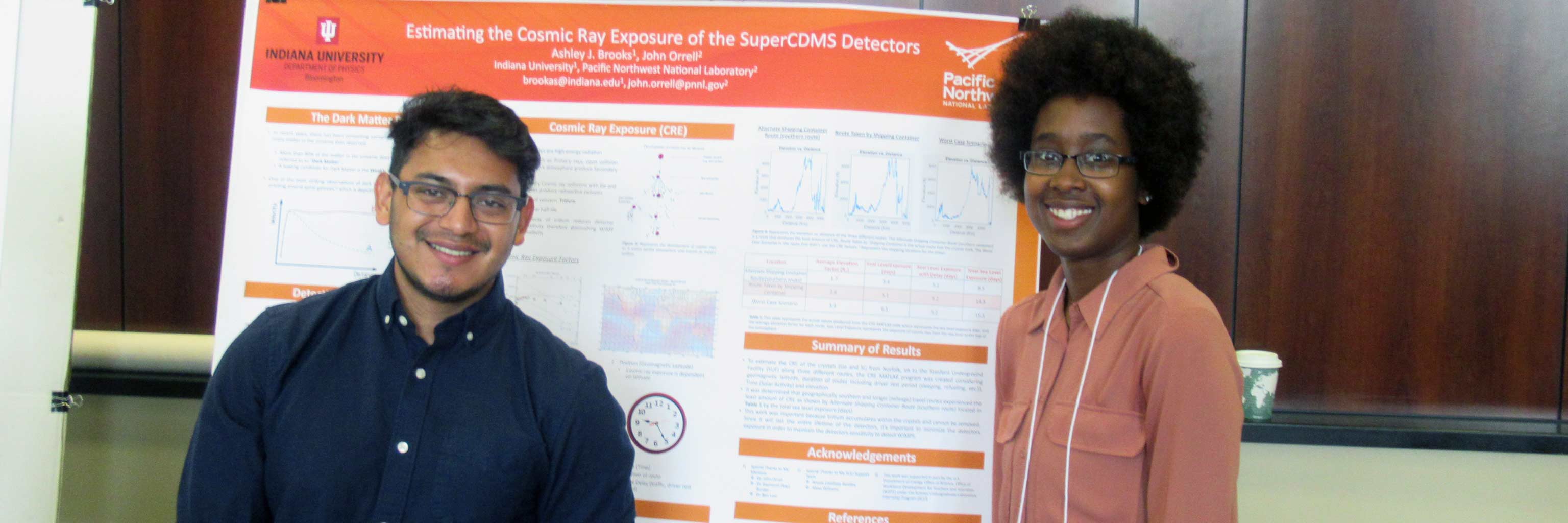 Two Bridge program students in front of a presentation board