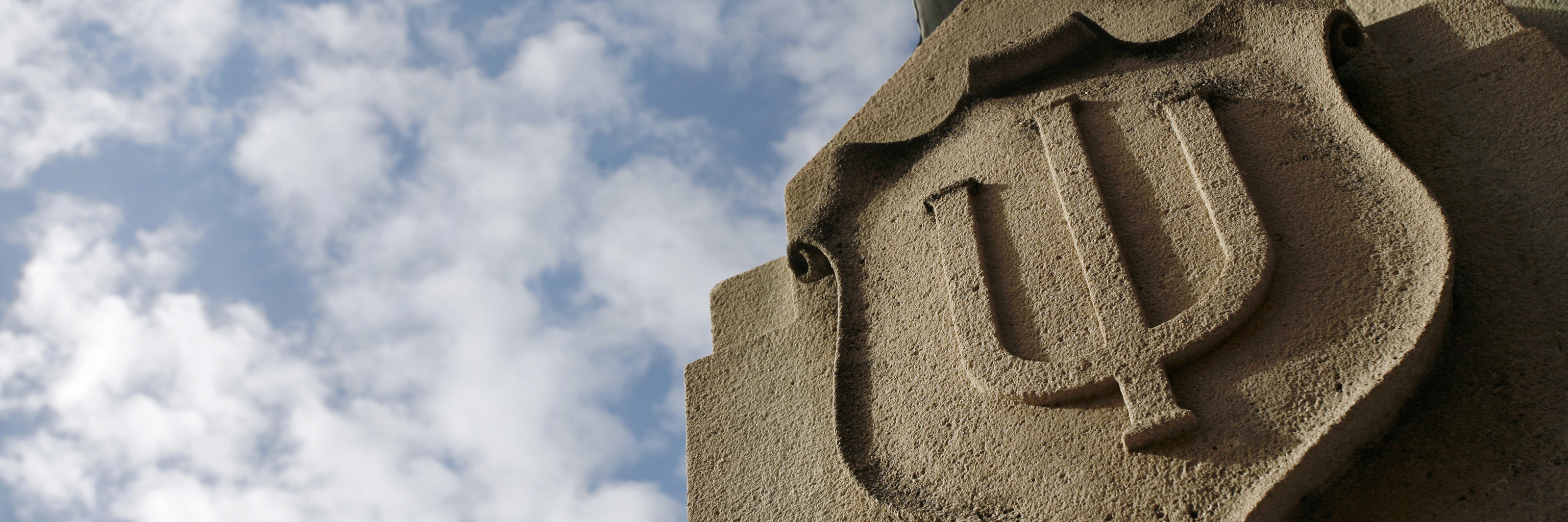 Limestone relief of a crest decorated with the Indiana University trident 