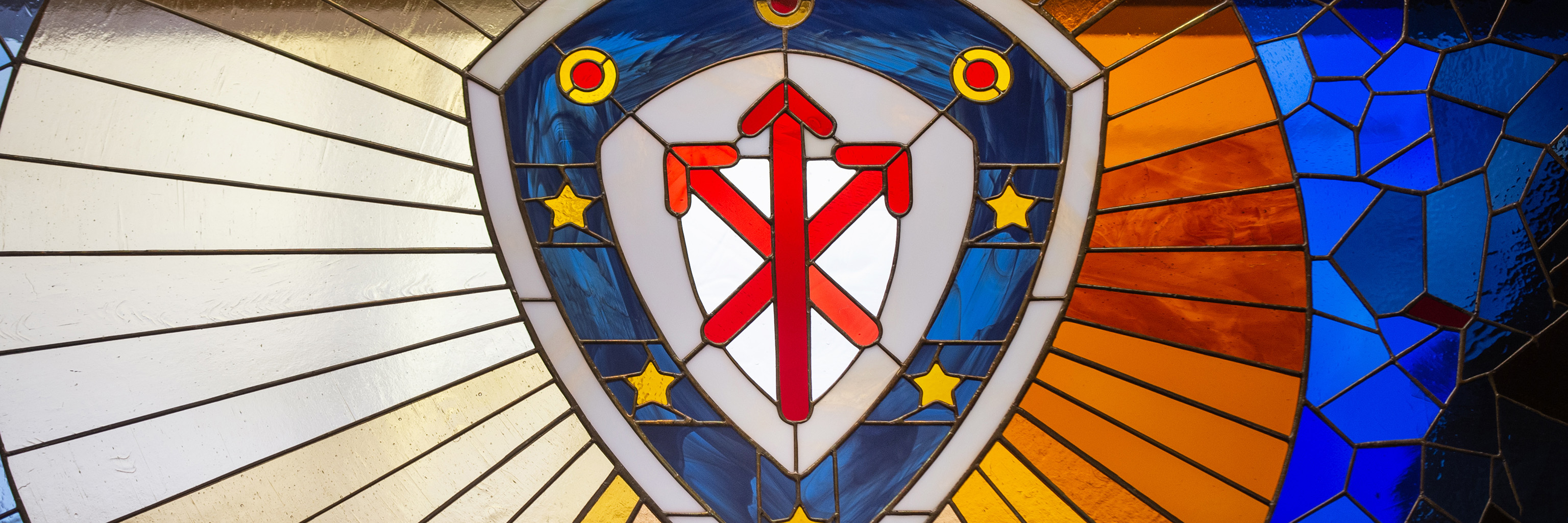 The Indiana University College of Arts and Sciences shield design displayed in stained glass