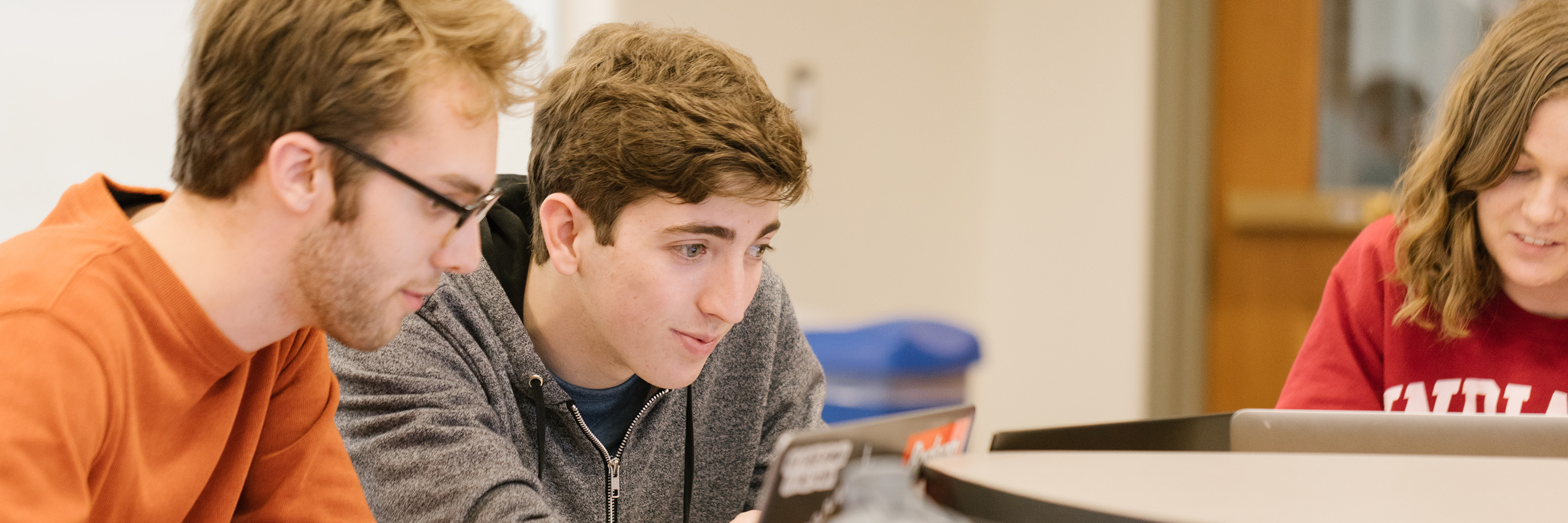 Two students working on a laptop together