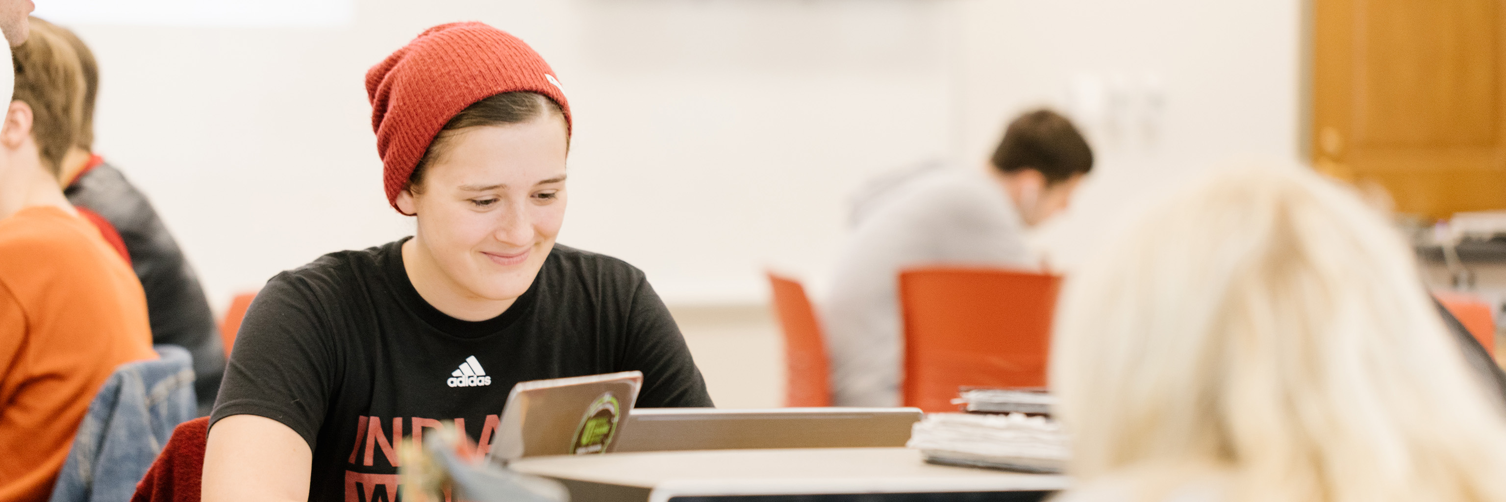 Student smiling as she works on her laptop