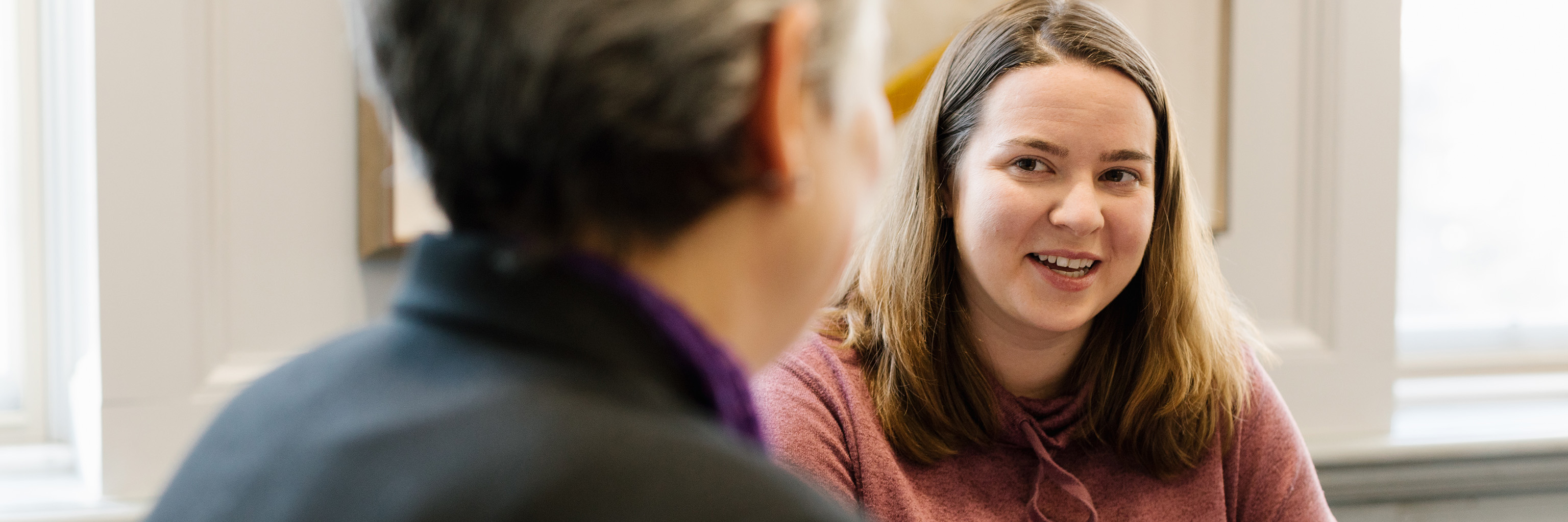 Over-the-shoulder image of a student speaking with an advisor.