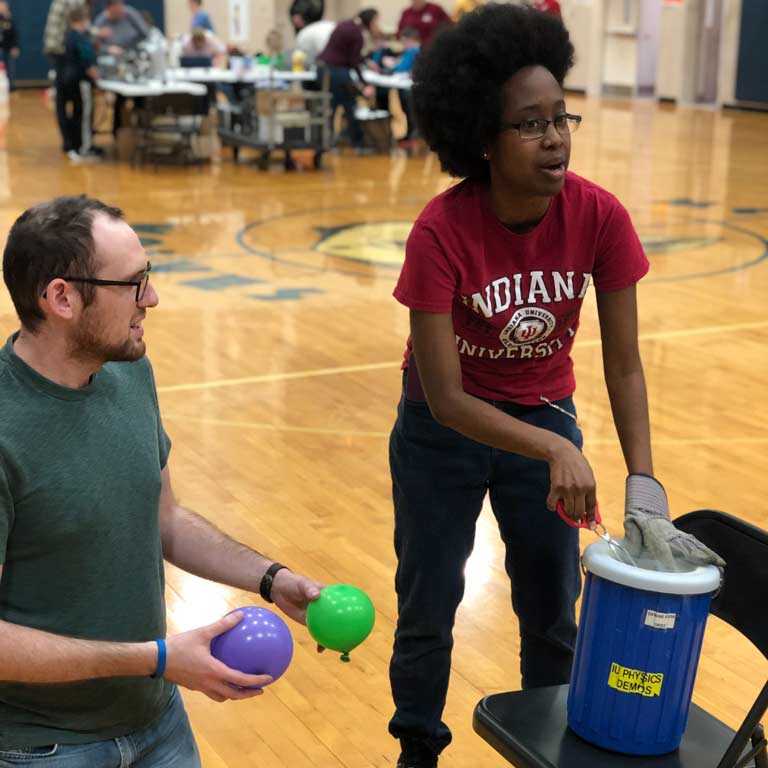 Two students performing a scientific demonstration