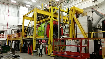 A man posing in a large, industrial lab setting
